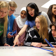 Students collaborating in a Math class on a project about city planning.